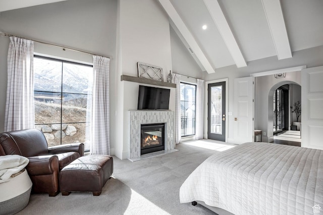 bedroom with access to exterior, arched walkways, light colored carpet, high vaulted ceiling, and beamed ceiling