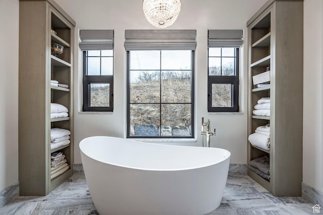 bathroom featuring a freestanding tub and an inviting chandelier