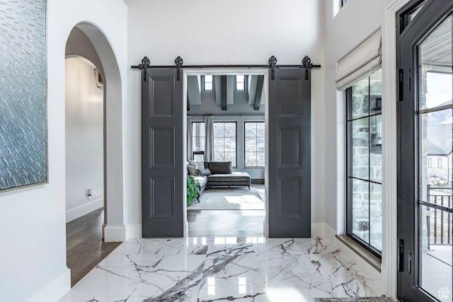 entryway featuring a healthy amount of sunlight, marble finish floor, and a barn door