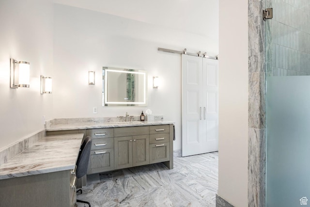 full bath featuring marble finish floor, walk in shower, and vanity