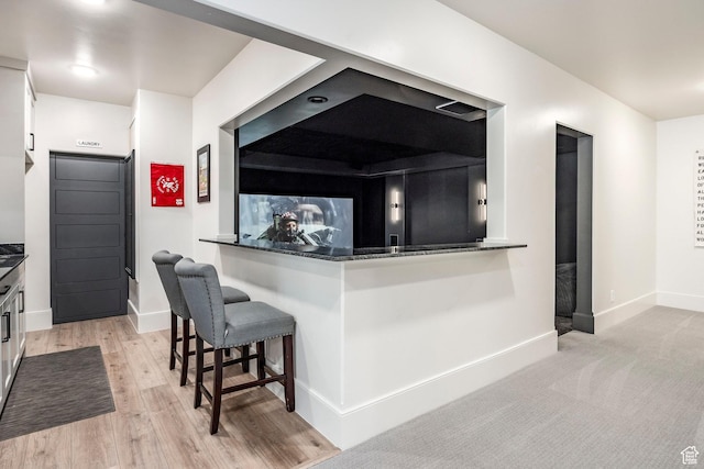 bar with light wood-type flooring and baseboards