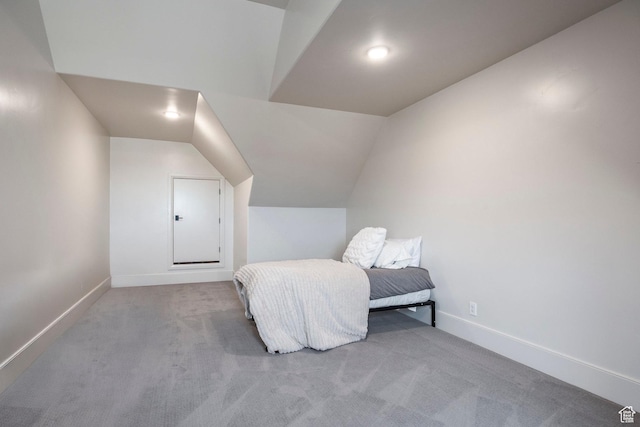 bedroom with lofted ceiling, carpet, and baseboards