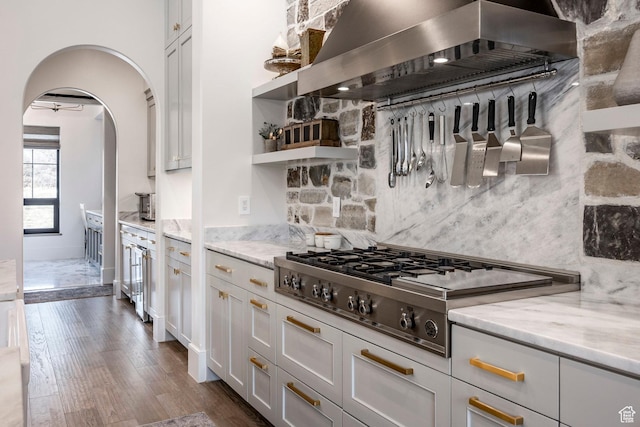 kitchen featuring decorative backsplash, dark wood-type flooring, stainless steel gas stovetop, open shelves, and exhaust hood