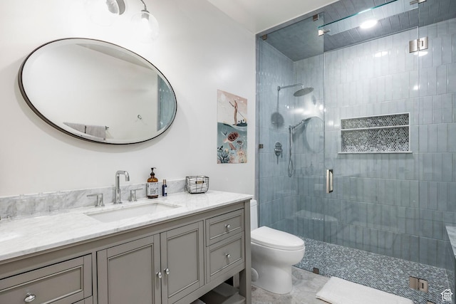 bathroom with toilet, a stall shower, and vanity