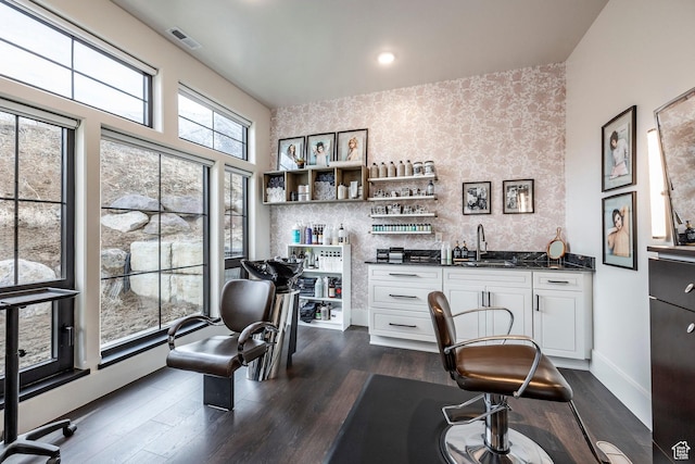 office area with wallpapered walls, baseboards, dark wood finished floors, indoor wet bar, and a sink