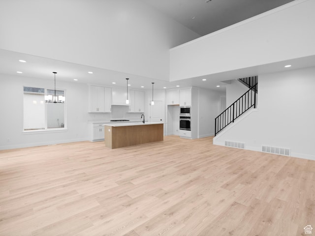 1171 W 800 S Unit 38, Spanish Fork, UT 84660 - unfurnished living room featuring a chandelier, light wood-style flooring, visible vents, and baseboards