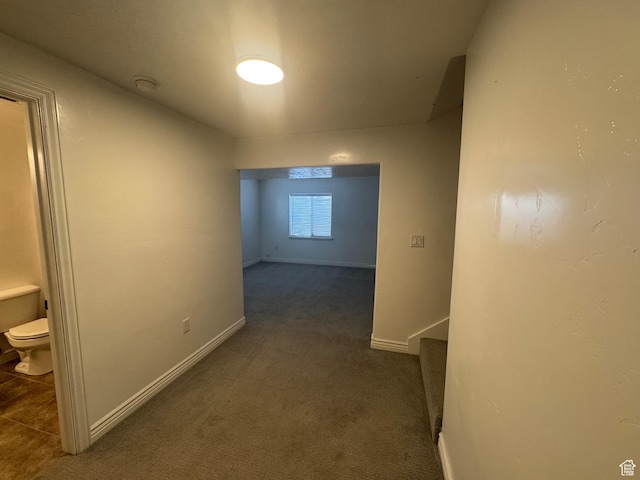 hallway with carpet and baseboards