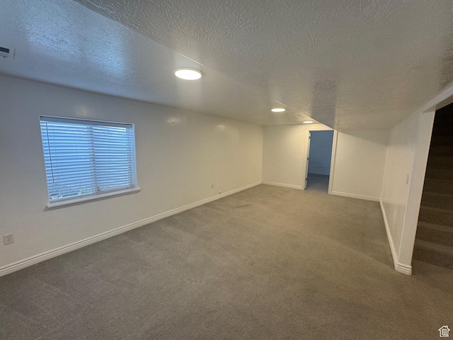 below grade area featuring carpet floors, stairway, visible vents, and baseboards