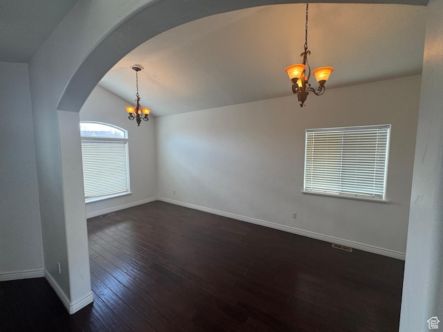 unfurnished room featuring vaulted ceiling, dark wood-type flooring, arched walkways, and a notable chandelier