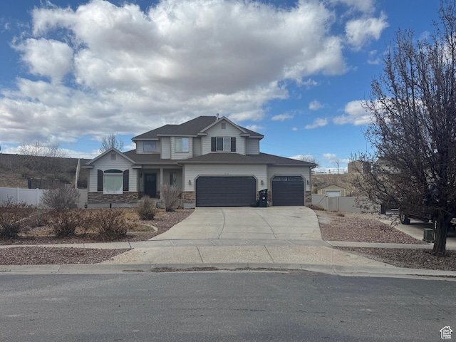 view of front of house with an attached garage, stone siding, fence, and concrete driveway