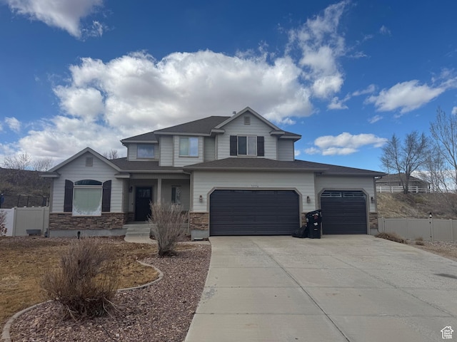 view of front of house with a garage, driveway, and fence