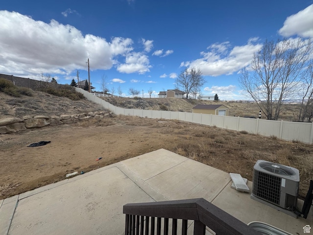 view of yard featuring a fenced backyard, a patio area, and cooling unit