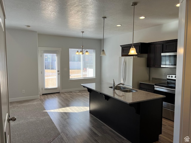 16368 S Coupler Ln, Bluffdale, UT 84065 - kitchen with an island with sink, appliances with stainless steel finishes, a textured ceiling, a kitchen bar, and a sink