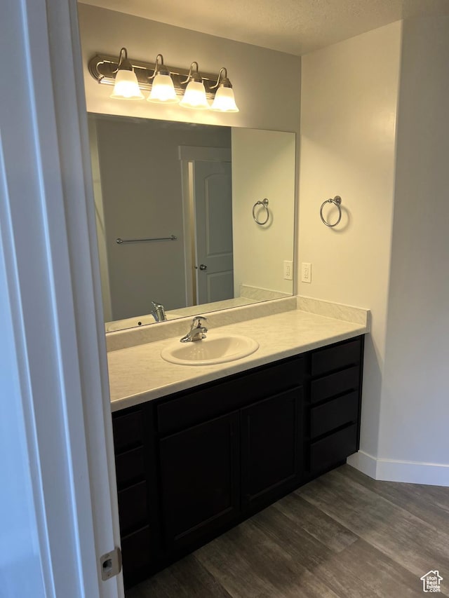 16368 S Coupler Ln, Bluffdale, UT 84065 - bathroom featuring a textured ceiling, vanity, baseboards, and wood finished floors