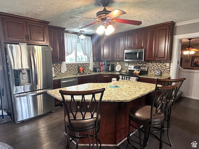 371 S Willard Peak Rd S, Mantua, UT 84324 - kitchen featuring a breakfast bar area, a ceiling fan, dark wood-style floors, stainless steel appliances, and tasteful backsplash