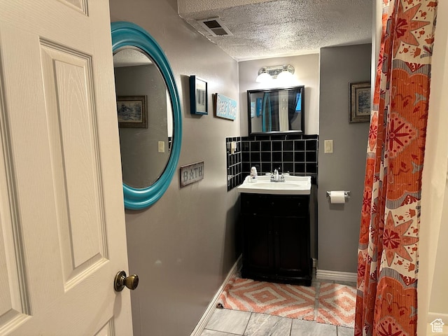 371 S Willard Peak Rd S, Mantua, UT 84324 - bathroom featuring visible vents, backsplash, a textured ceiling, wood finished floors, and vanity