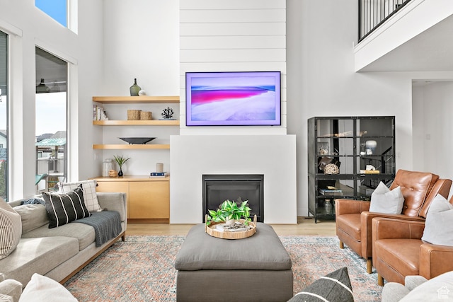 1228 E 1030 N, American Fork, UT 84003 - living room with light wood-type flooring, a fireplace, and a towering ceiling