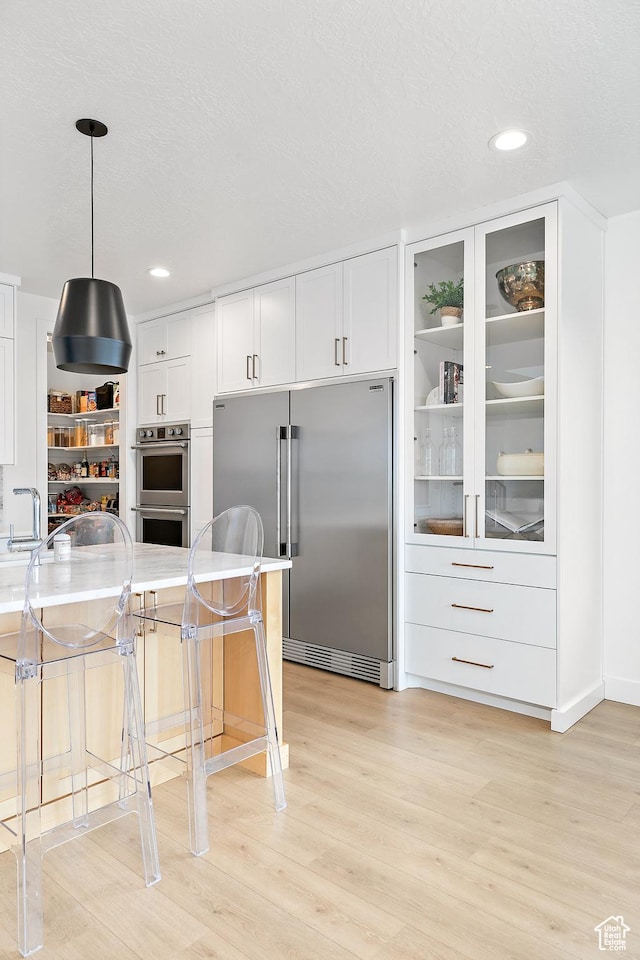 1228 E 1030 N, American Fork, UT 84003 - kitchen featuring stainless steel appliances, light wood-type flooring, pendant lighting, and white cabinetry