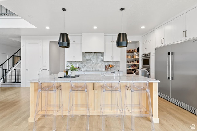 1228 E 1030 N, American Fork, UT 84003 - kitchen with tasteful backsplash, a large island, appliances with stainless steel finishes, light wood-style floors, and white cabinetry