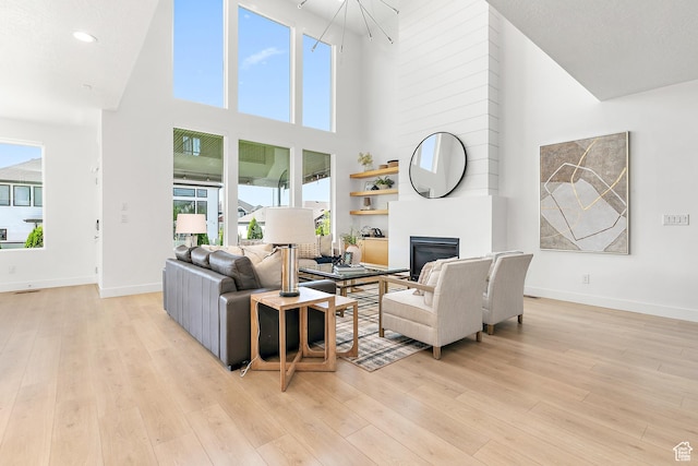 1228 E 1030 N, American Fork, UT 84003 - living room featuring a high ceiling, a glass covered fireplace, light wood-style flooring, recessed lighting, and a chandelier