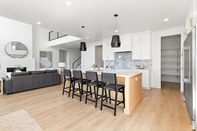 1228 E 1030 N, American Fork, UT 84003 - kitchen featuring light wood finished floors, open floor plan, tasteful backsplash, a kitchen bar, and recessed lighting