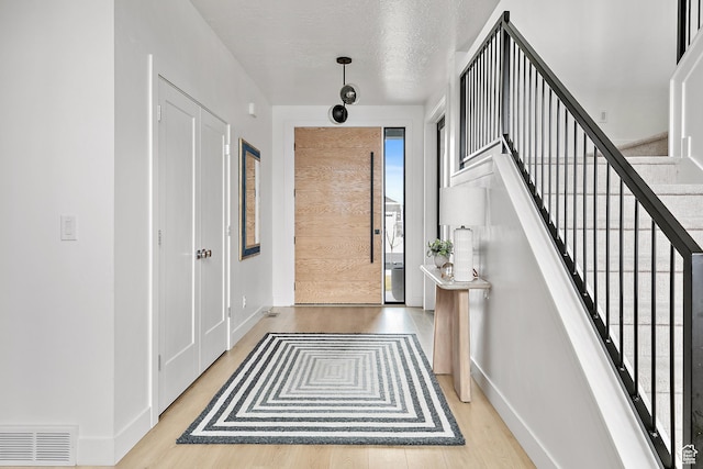 1228 E 1030 N, American Fork, UT 84003 - entryway with baseboards, visible vents, stairway, wood finished floors, and a textured ceiling