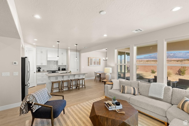 4712 W 2820 S, Hurricane, UT 84737 - living area featuring baseboards, light wood finished floors, recessed lighting, and a textured ceiling