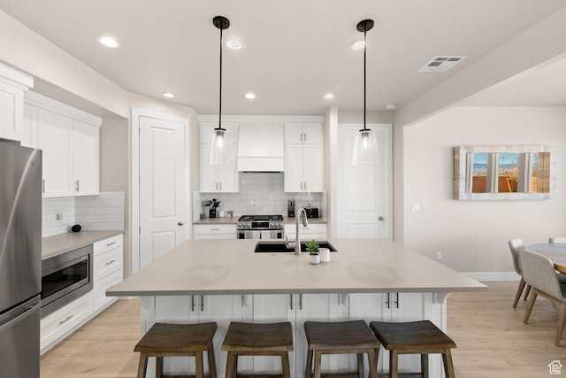 4712 W 2820 S, Hurricane, UT 84737 - kitchen with stainless steel appliances, premium range hood, a breakfast bar, a sink, and recessed lighting
