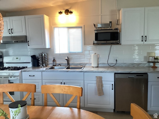 255 N 1st St E, Manila, UT 84046 - kitchen featuring a sink, stainless steel appliances, under cabinet range hood, tasteful backsplash, and white cabinetry