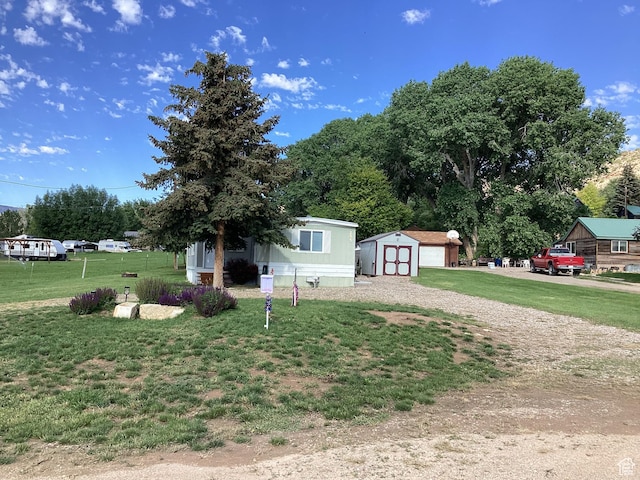 255 N 1st St E, Manila, UT 84046 - view of front of home featuring a storage shed, a front lawn, driveway, and a detached garage