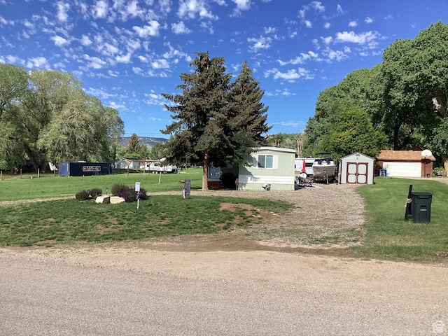 255 N 1st St E, Manila, UT 84046 - view of front of home with a storage shed, dirt driveway, a front lawn, and a detached garage