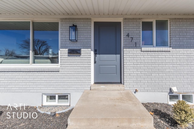 doorway to property featuring brick siding