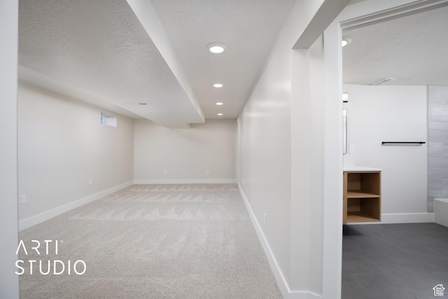 finished basement with carpet floors, baseboards, a textured ceiling, and recessed lighting