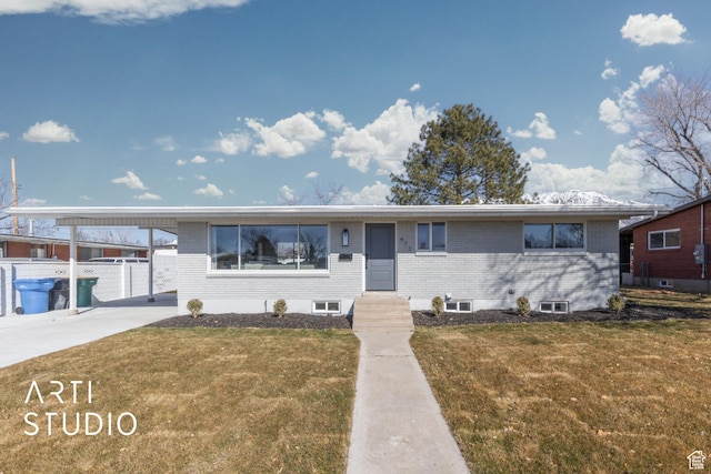 ranch-style house with concrete driveway, brick siding, and a front lawn