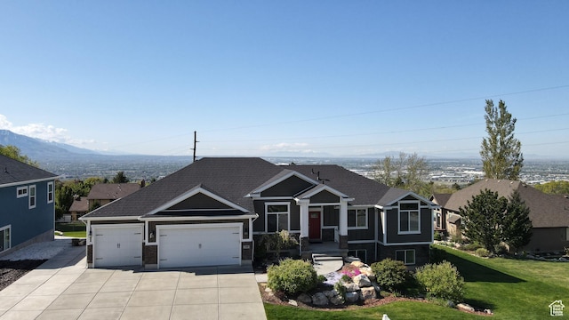 view of front facade featuring a garage, a shingled roof, concrete driveway, and a front lawn
