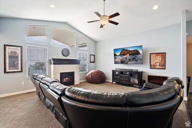 carpeted living area with a healthy amount of sunlight, ceiling fan, a fireplace, and vaulted ceiling