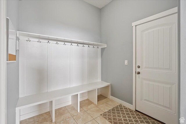 mudroom with tile patterned floors and baseboards