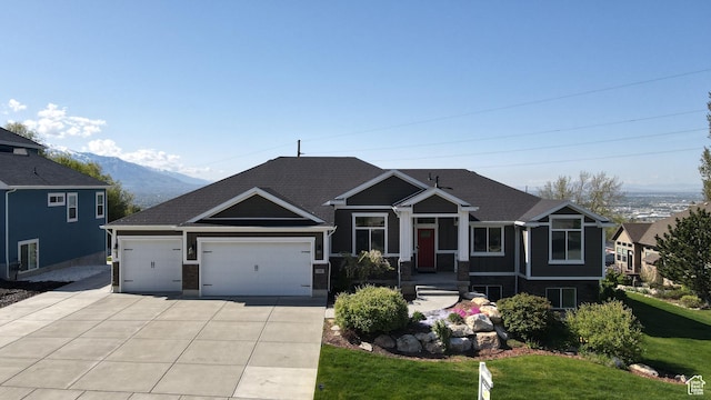 craftsman house featuring a garage, a mountain view, driveway, and a front lawn