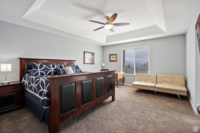 carpeted bedroom featuring baseboards, a raised ceiling, and ceiling fan