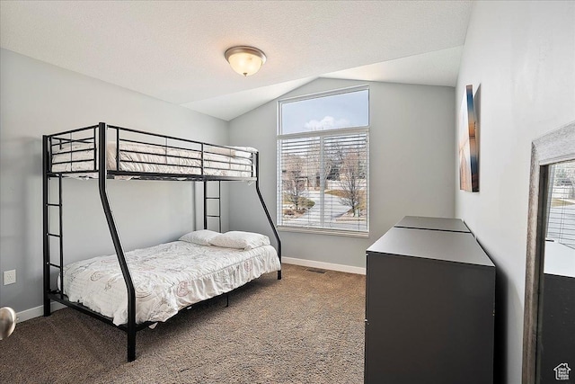 bedroom featuring baseboards, visible vents, lofted ceiling, and dark colored carpet