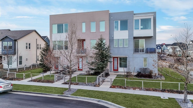 view of front of home with a front lawn, a fenced front yard, and stucco siding