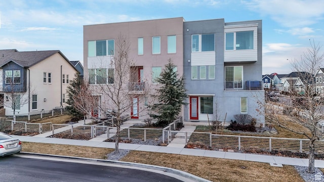 view of front of home with a fenced front yard and stucco siding