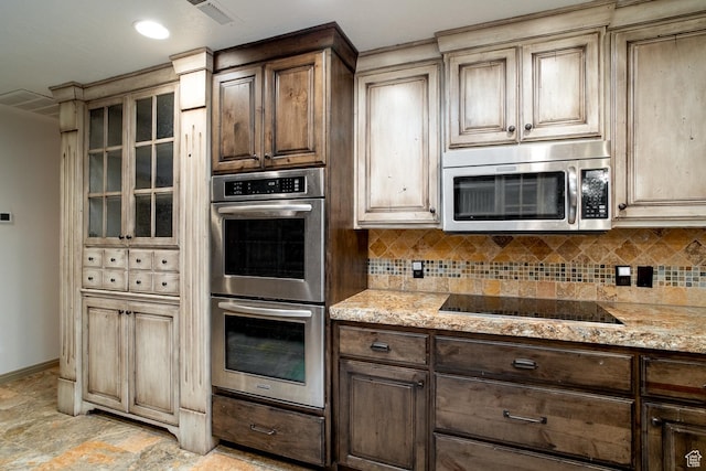 kitchen with visible vents, stainless steel appliances, tasteful backsplash, and light stone counters