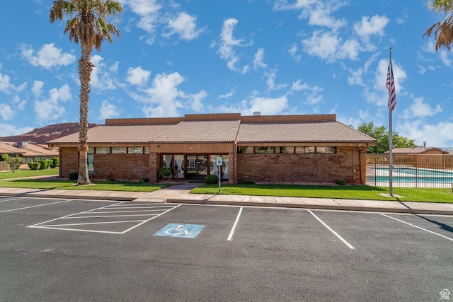view of property with uncovered parking, fence, and a community pool