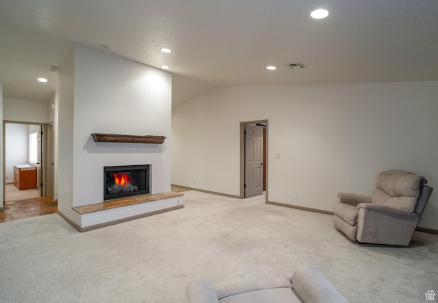 living area with lofted ceiling, a lit fireplace, visible vents, and light carpet