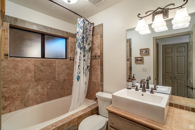full bathroom with visible vents, toilet, tiled shower / bath combo, a textured ceiling, and vanity
