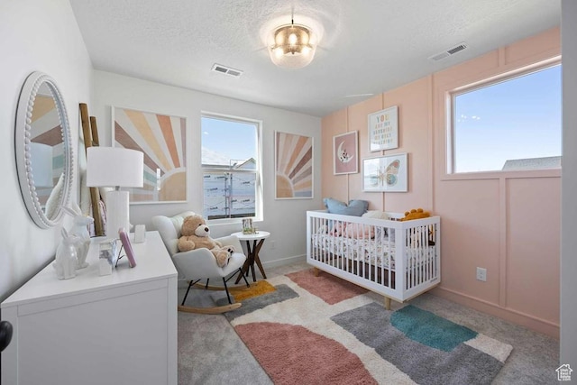 2893 S Malcom Pl Unit 9, West Valley City, UT 84128 - bedroom featuring a textured ceiling, a nursery area, and carpet flooring