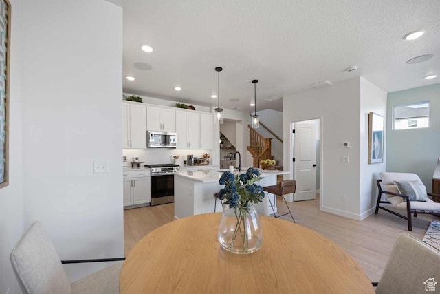 2893 S Malcom Pl Unit 9, West Valley City, UT 84128 - dining room with stairway, light wood finished floors, and recessed lighting