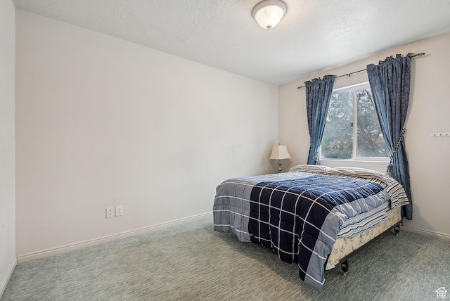 bedroom with a textured ceiling, carpet flooring, and baseboards