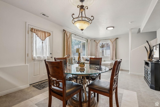 dining space featuring light tile patterned floors, baseboards, and visible vents